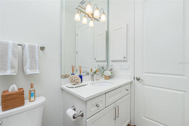 bathroom featuring an inviting chandelier, vanity, and toilet