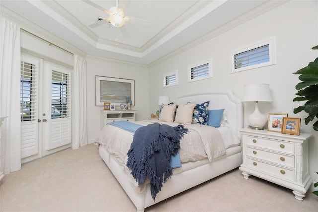 bedroom with light colored carpet, ceiling fan, a tray ceiling, and access to exterior