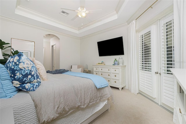 carpeted bedroom featuring a raised ceiling, ceiling fan, and crown molding