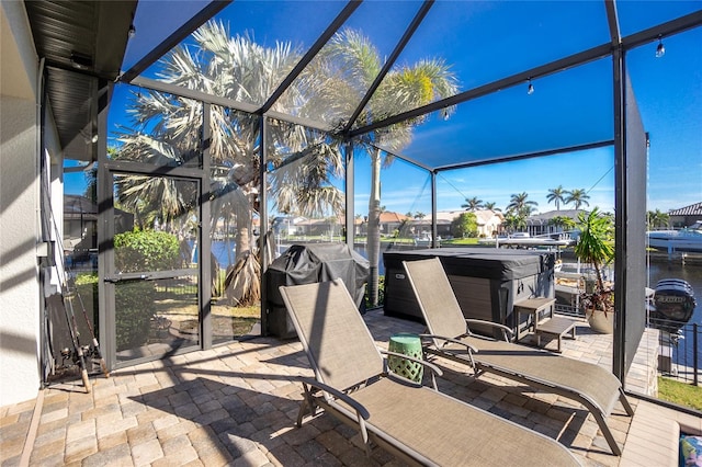 view of patio featuring a lanai, a hot tub, and area for grilling