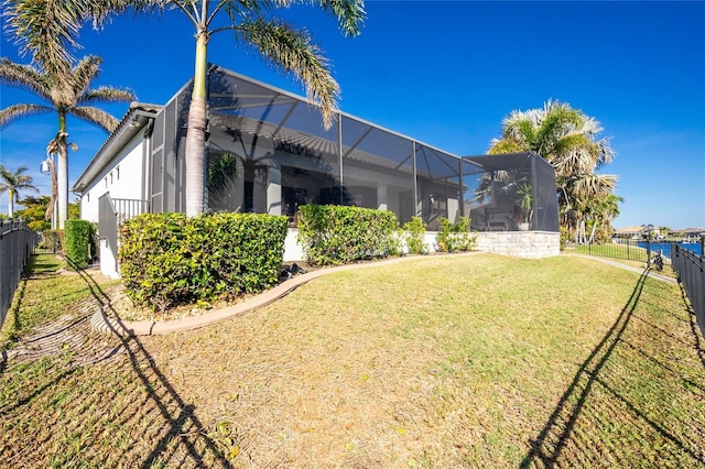 exterior space featuring glass enclosure and a lawn