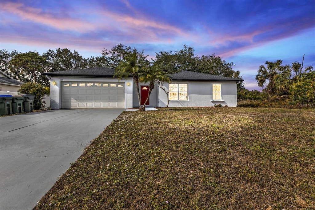 view of front of property with a garage and a lawn