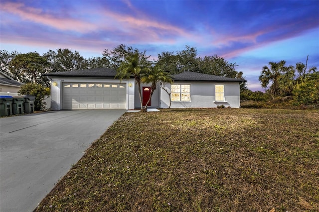 view of front of property with a garage and a lawn