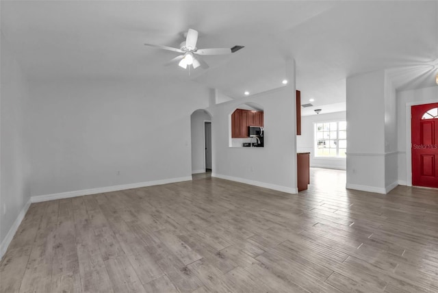 unfurnished living room featuring ceiling fan and light wood-type flooring