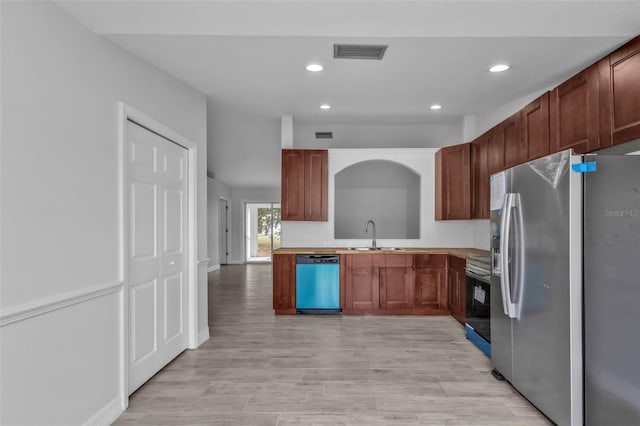 kitchen with appliances with stainless steel finishes, light hardwood / wood-style floors, and sink