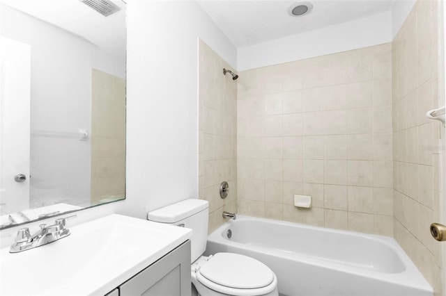 full bathroom with toilet, vanity, and tiled shower / bath combo