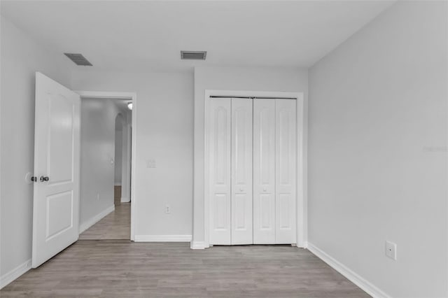 unfurnished bedroom featuring a closet and light hardwood / wood-style flooring