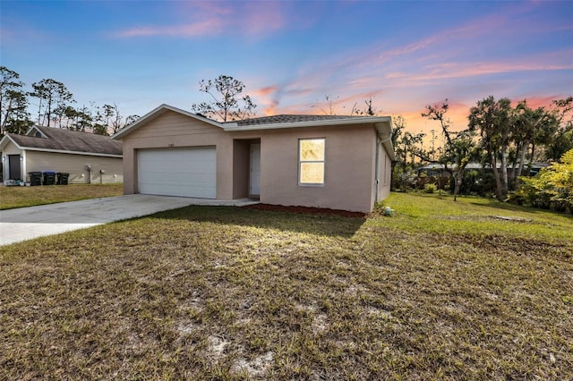 single story home featuring a lawn and a garage