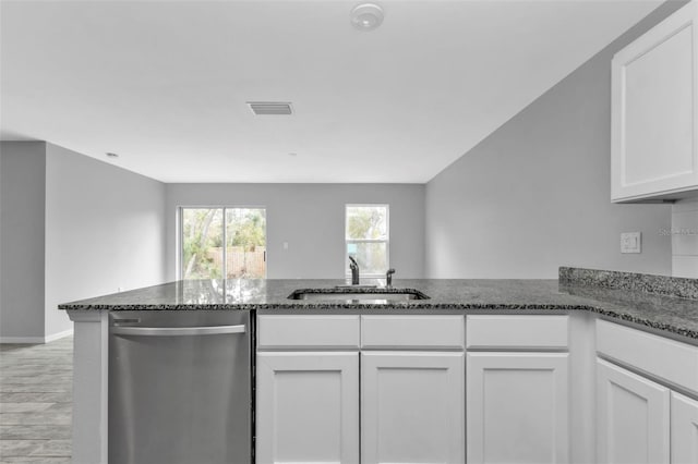 kitchen featuring sink, white cabinetry, dark stone countertops, and dishwasher