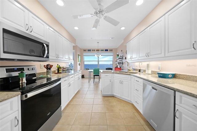 kitchen featuring stainless steel appliances, white cabinets, and pendant lighting