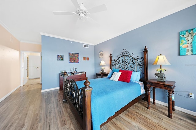 bedroom with ceiling fan, crown molding, and wood-type flooring