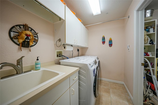 laundry area featuring independent washer and dryer, a textured ceiling, light tile patterned floors, cabinets, and sink