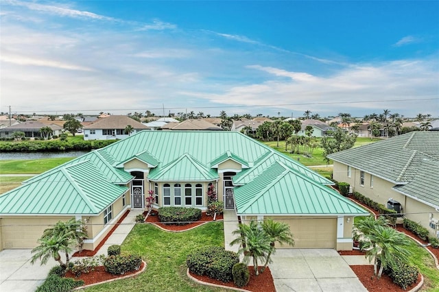 single story home with a water view, a garage, and a front yard