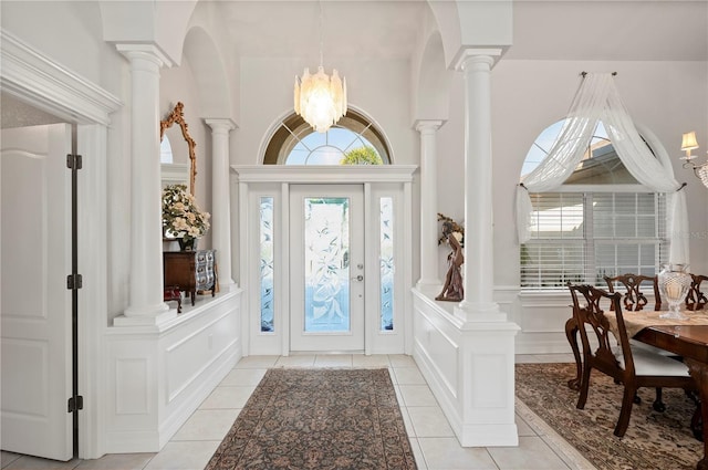 tiled foyer featuring an inviting chandelier and plenty of natural light