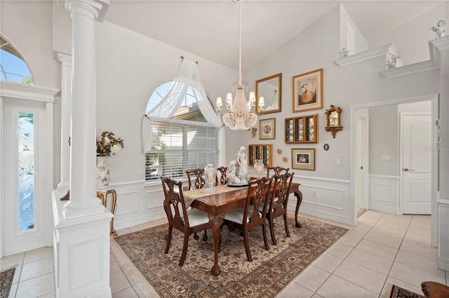 dining space with an inviting chandelier, vaulted ceiling, light tile patterned flooring, and ornate columns