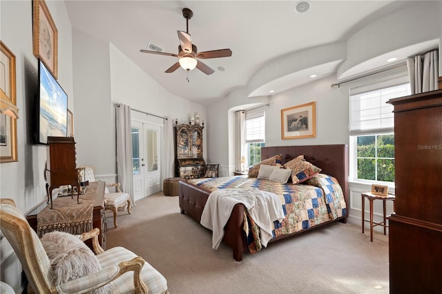 carpeted bedroom featuring french doors, multiple windows, ceiling fan, and vaulted ceiling