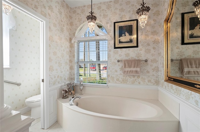 bathroom with a bathing tub, tile patterned flooring, and toilet