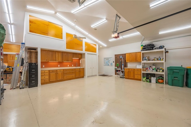 garage featuring a garage door opener, ceiling fan, and sink