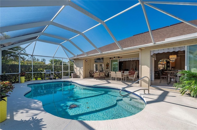 view of swimming pool featuring ceiling fan, a patio, glass enclosure, and grilling area