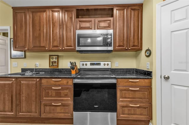 kitchen featuring dark stone counters and appliances with stainless steel finishes