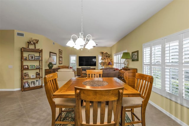 tiled dining room with an inviting chandelier