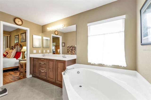 bathroom featuring a washtub, vanity, and tile patterned floors