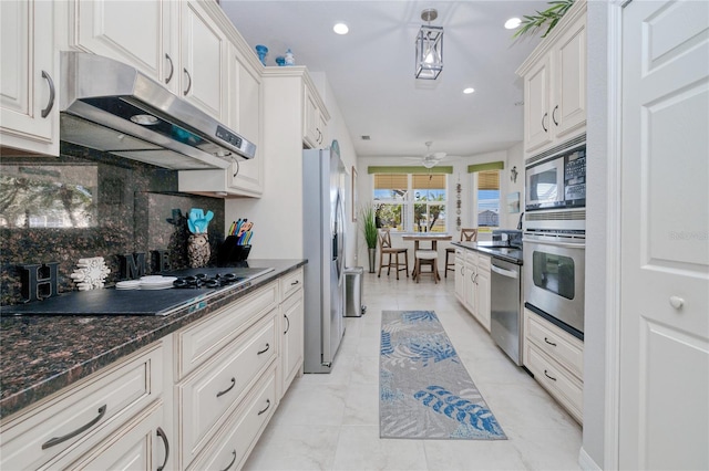 kitchen with hanging light fixtures, tasteful backsplash, white cabinetry, appliances with stainless steel finishes, and ceiling fan