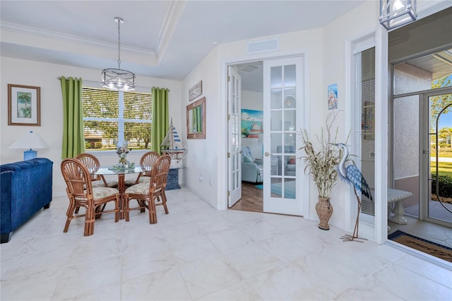 dining room featuring french doors, a raised ceiling, an inviting chandelier, and crown molding