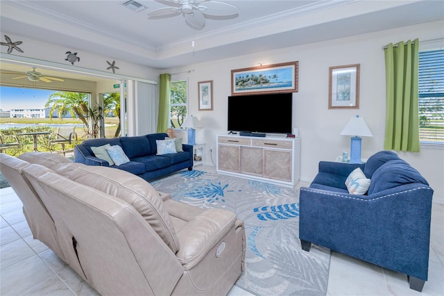 tiled living room featuring ornamental molding and a raised ceiling