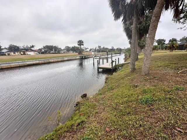 dock area with a lawn and a water view