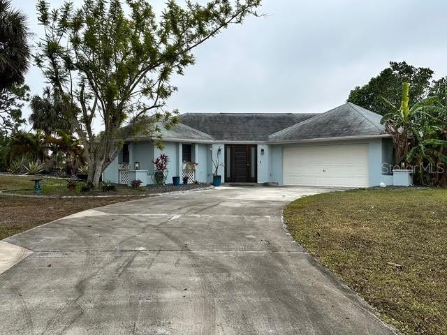 ranch-style home with a front lawn and a garage