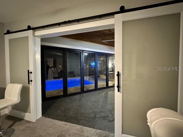 entryway featuring dark colored carpet and a barn door