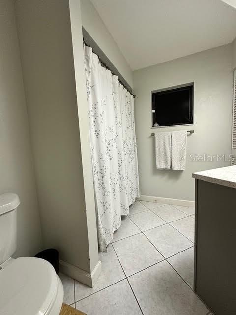 bathroom with toilet, tile patterned floors, and vanity