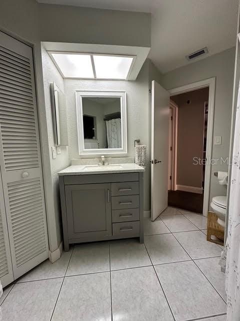 bathroom featuring tile patterned flooring, vanity, and toilet