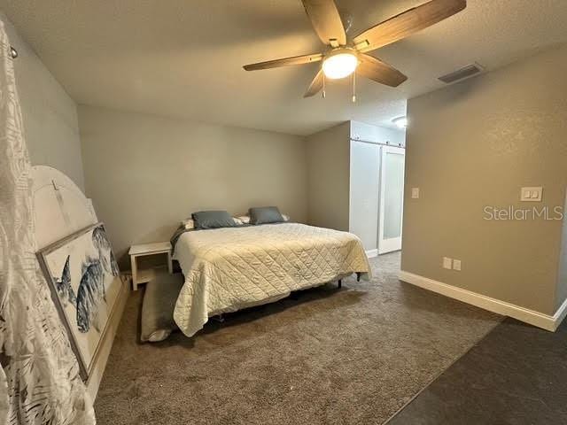 bedroom with dark carpet and ceiling fan