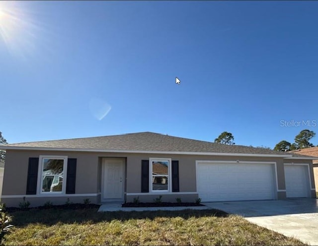 ranch-style house featuring a garage and a front lawn