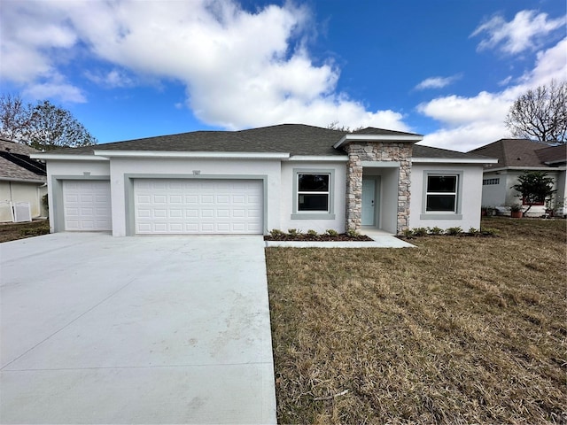 prairie-style home with an attached garage, concrete driveway, stone siding, stucco siding, and a front lawn