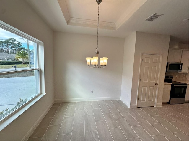 empty room featuring baseboards, visible vents, a raised ceiling, and a notable chandelier