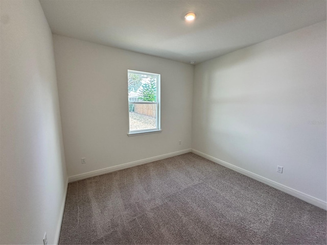 unfurnished room with carpet and baseboards