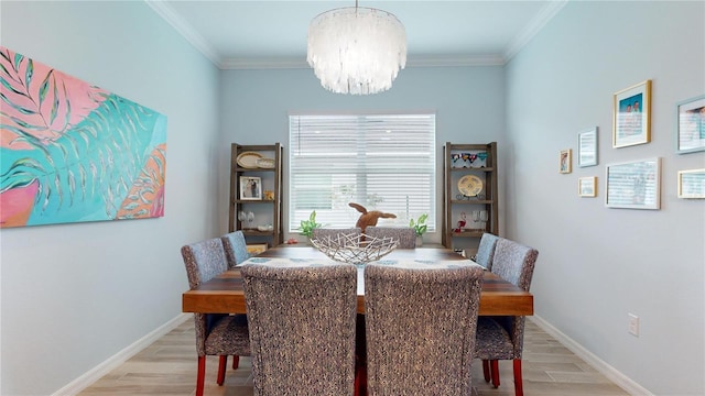 dining space featuring ornamental molding, an inviting chandelier, and light hardwood / wood-style floors