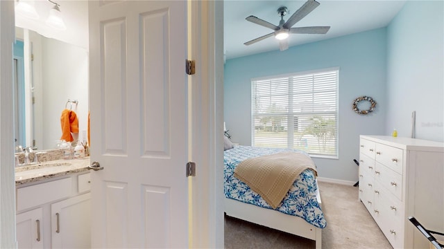 bedroom featuring light colored carpet, ceiling fan, and sink