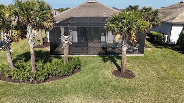 rear view of property featuring a patio area, glass enclosure, and a yard