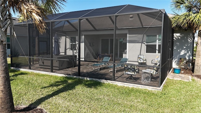 rear view of property featuring a patio area, glass enclosure, and a lawn