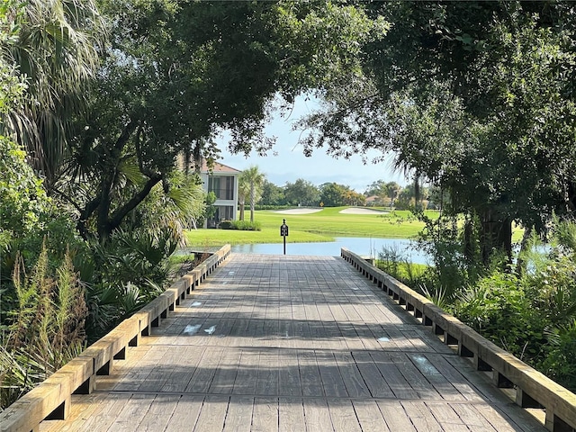 view of property's community featuring a lawn and a water view