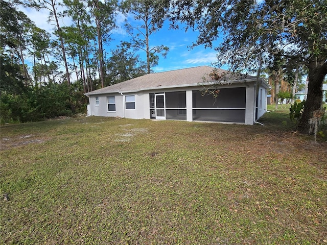 back of property featuring a sunroom and a yard