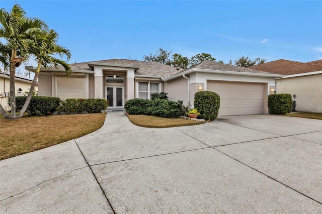 view of front of house featuring a front lawn, french doors, and a garage