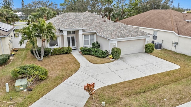 ranch-style home with central AC unit, a front lawn, and a garage