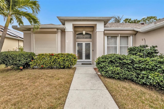 view of exterior entry featuring french doors and a yard