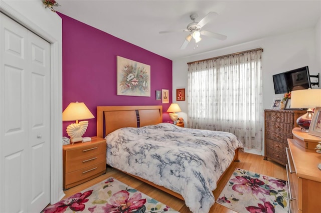 bedroom featuring light hardwood / wood-style flooring, ceiling fan, and a closet