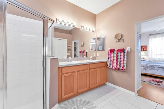 bathroom featuring ceiling fan, tile patterned floors, a shower with door, and vanity